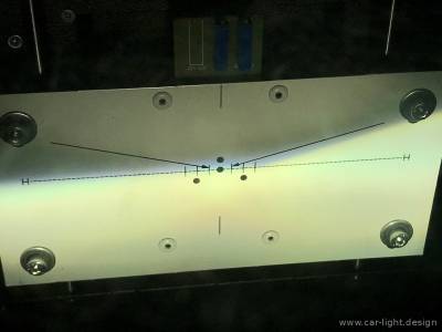 Проекция света галогенных линз на эталонную шкалу регулировки фар